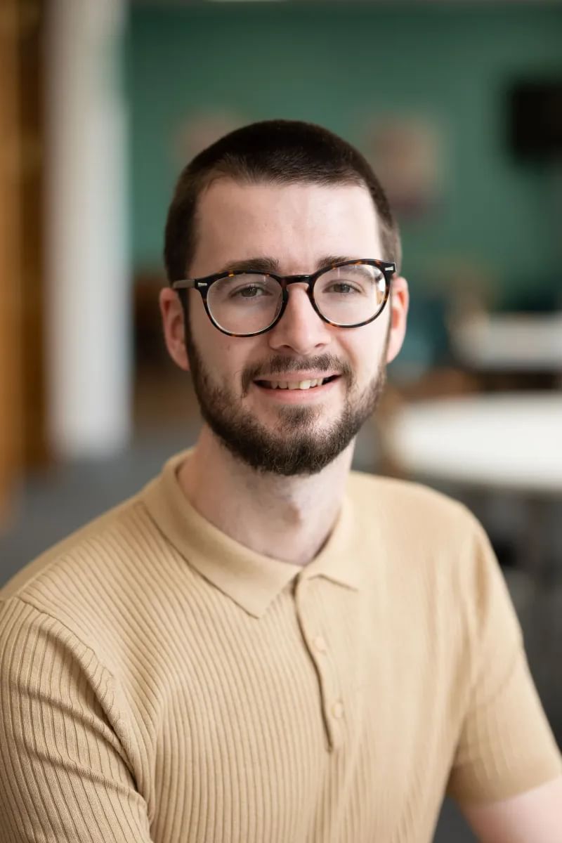 Dr Ieuan Grffiths smiling at the camera from the Postgraduate Centre in the Crawshays Building at Treforest campus