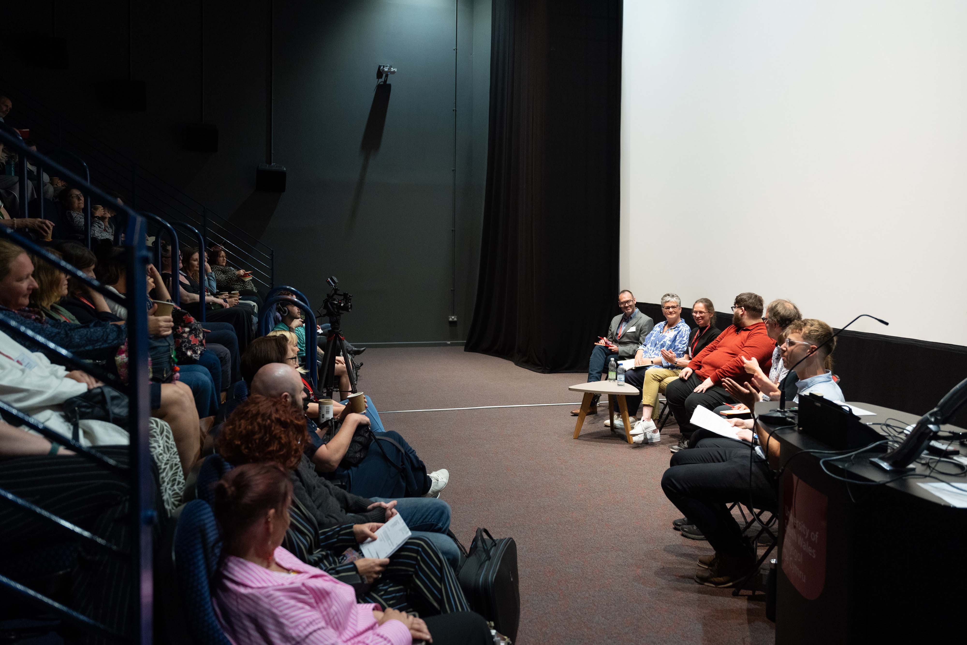 An audience listening to a panel discussion at a conference.