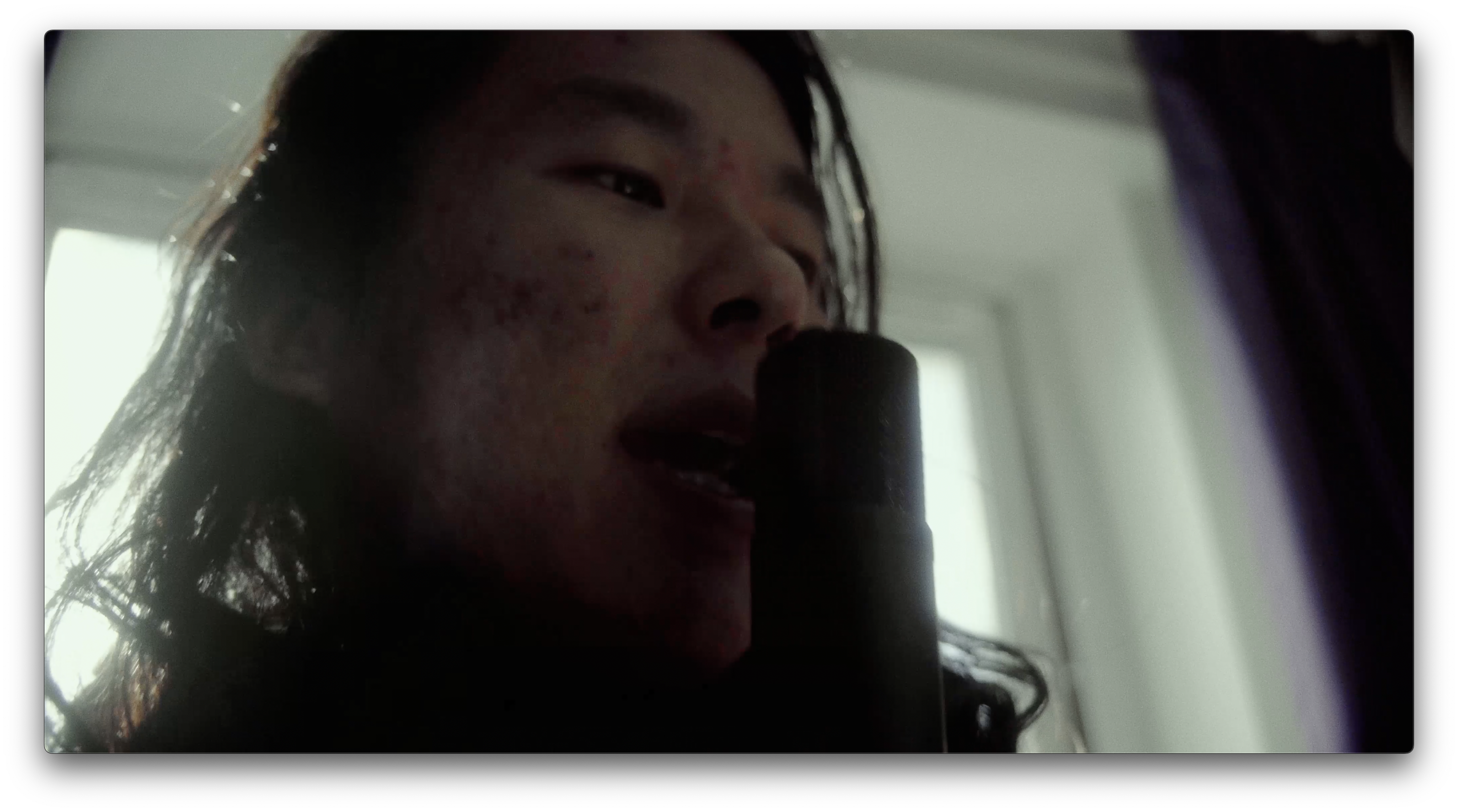 A close up of a person singing into a microphone.