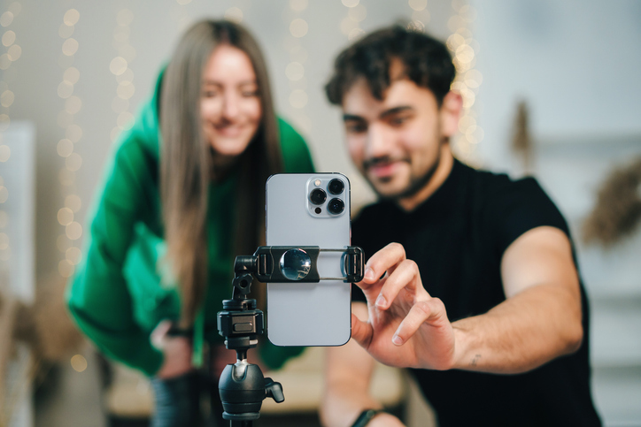 Two students setting up a mobile phone ready to film a video