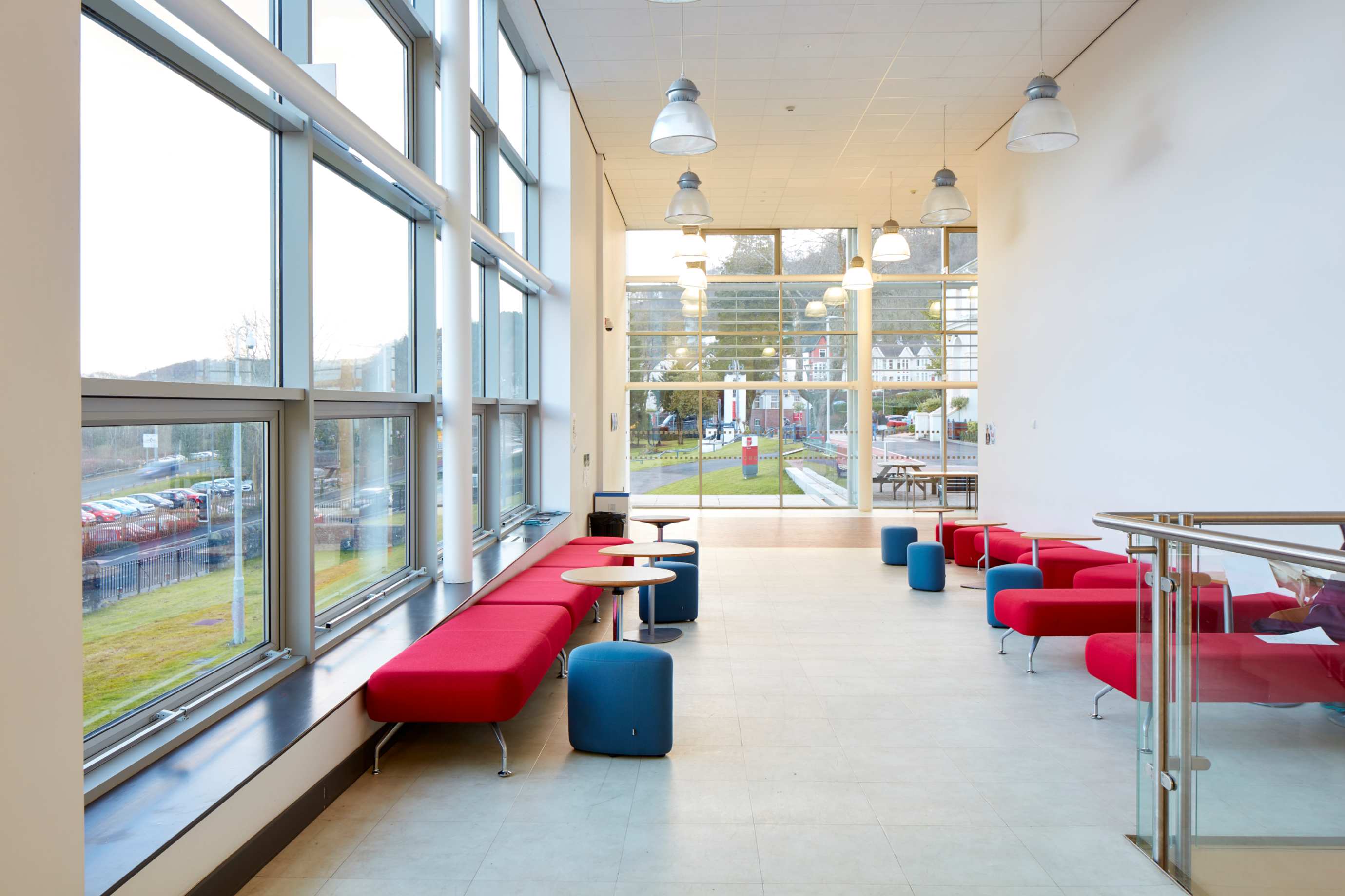inside view of the brecon building at Pontypridd campus, Treforest. Seating area inside the main entrance of the building with ceiling to floor windows and red sofas
