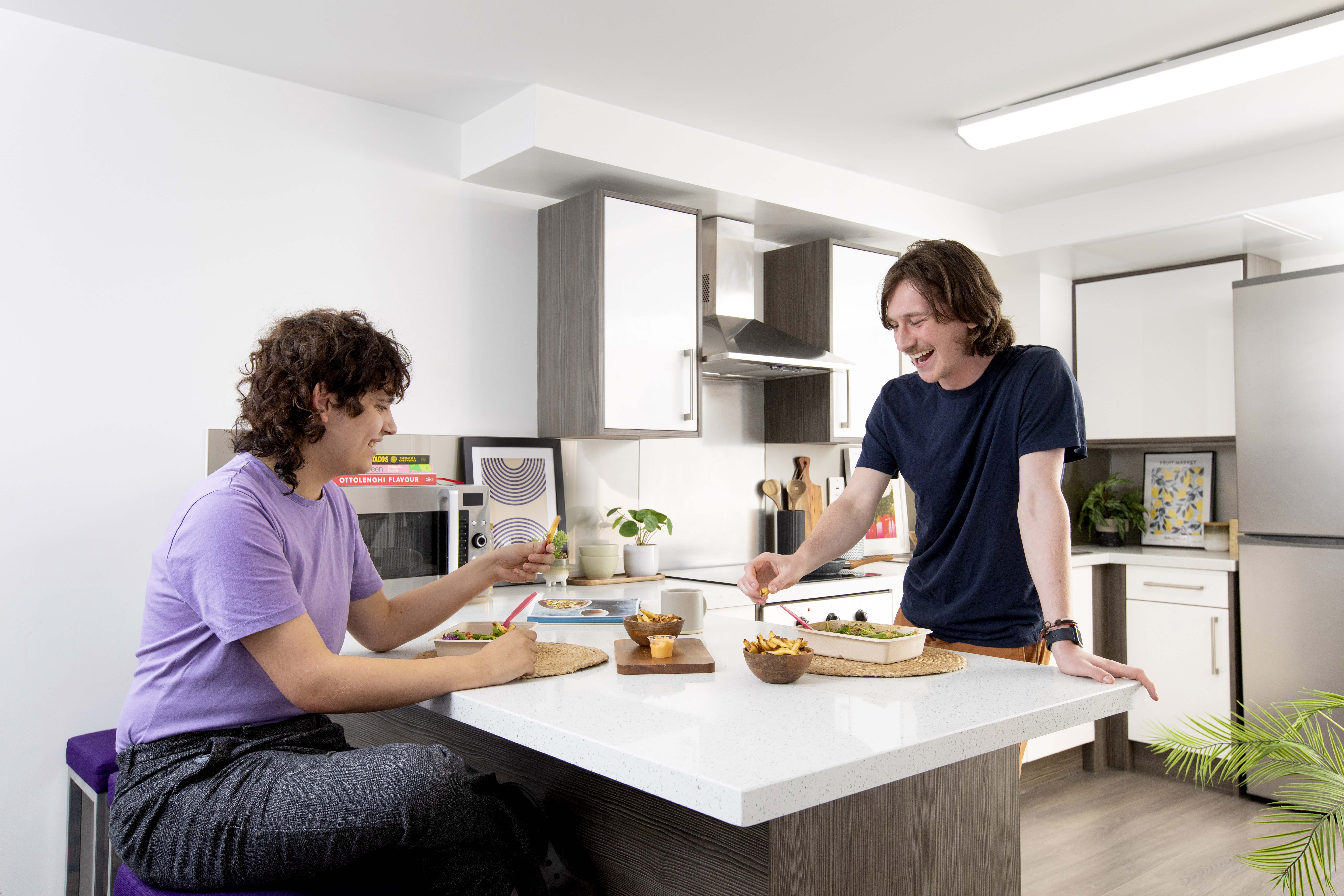 A shared kitchen in Ty Pont Haearn. There are students talking and laughing.