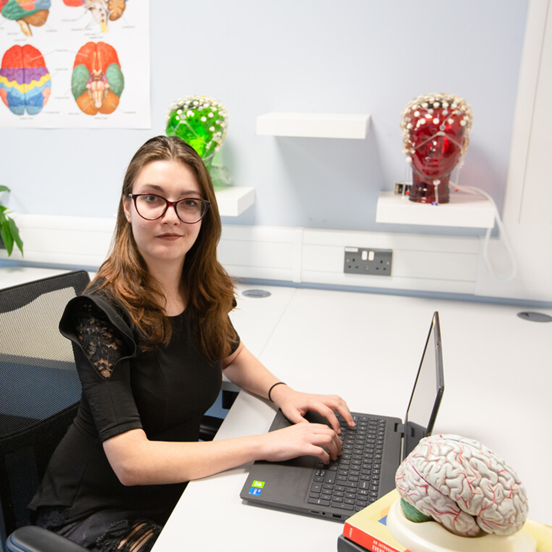 A student working on her laptop in the psychology lab
