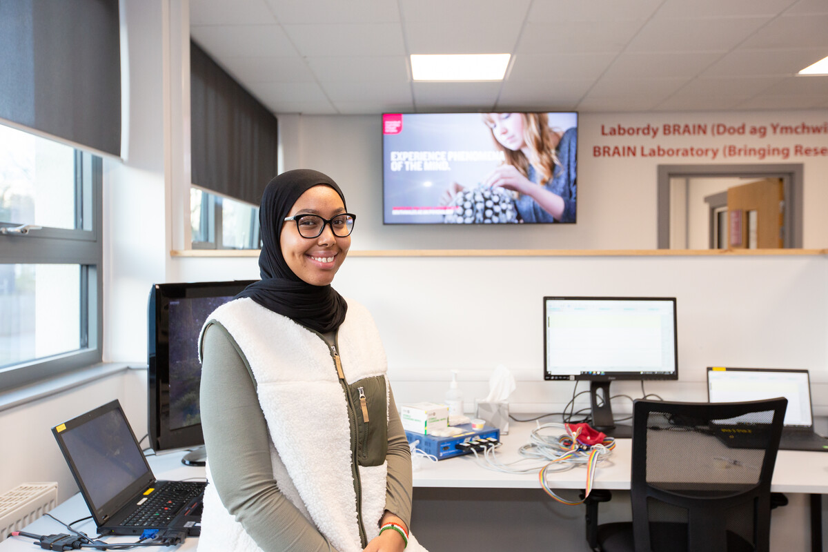 A student smiling at the camera in the psychology BRAIN lab