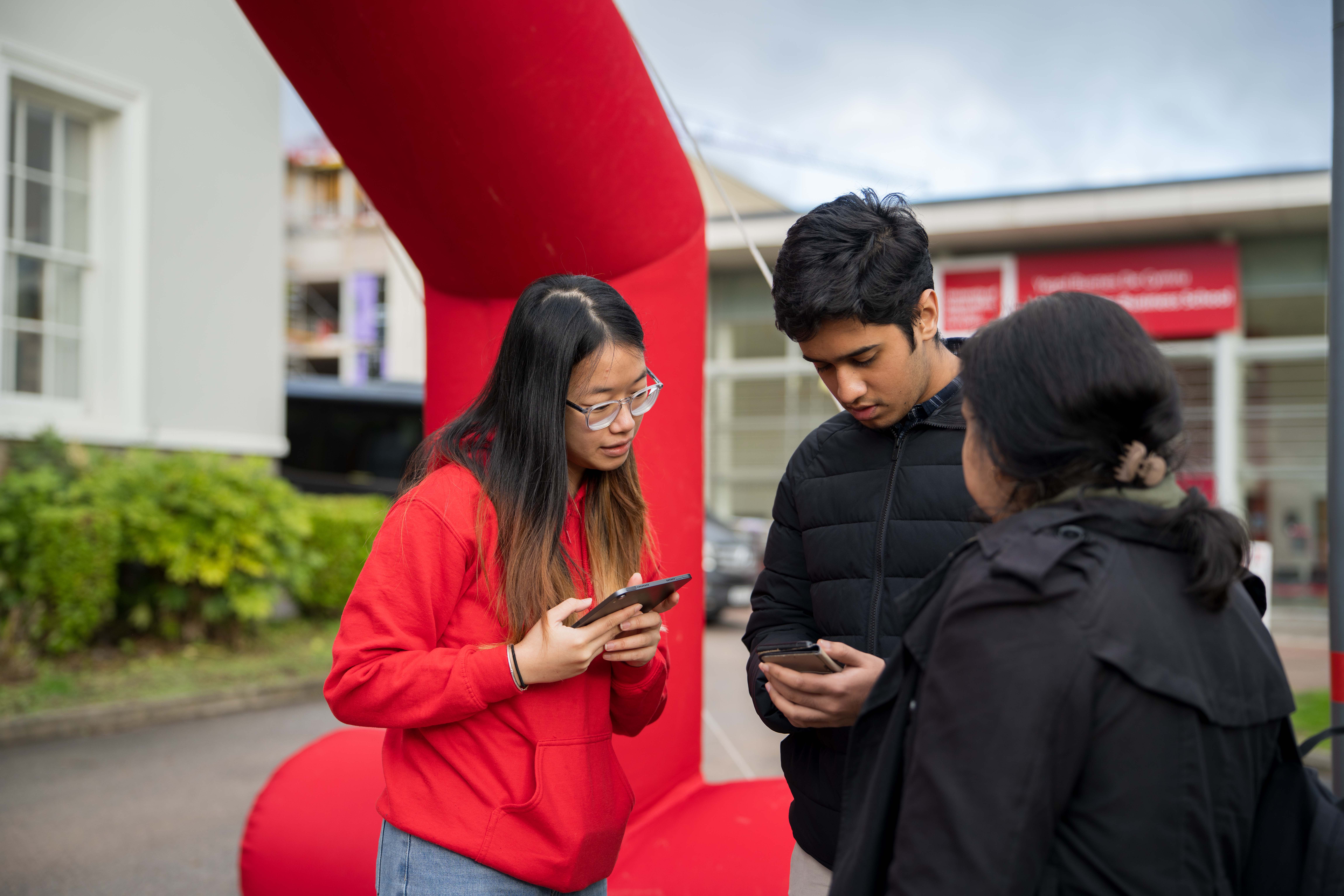 A student ambassador checking-in two guests for an open day.