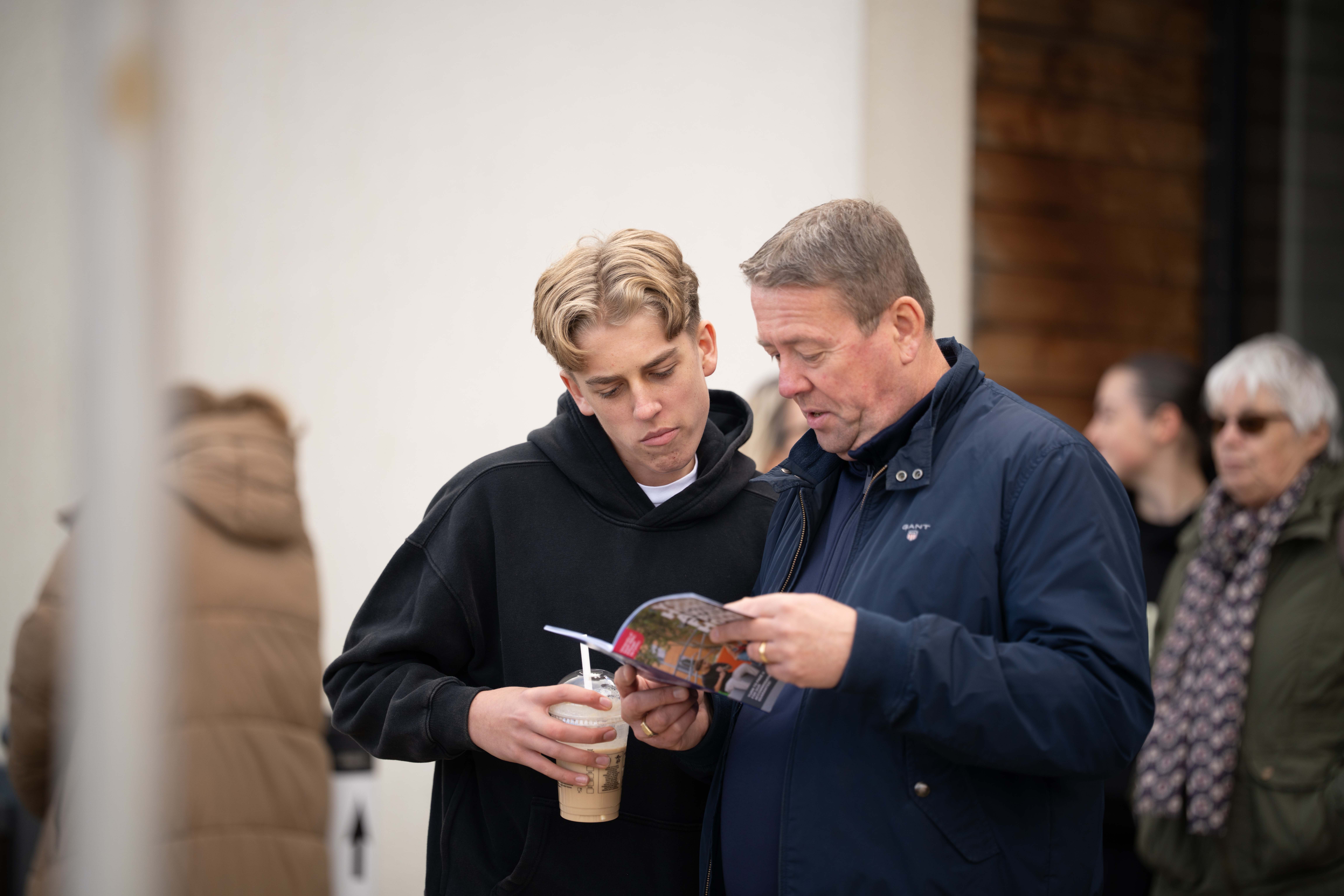 A young man and his guardian looking over Open Day handouts.