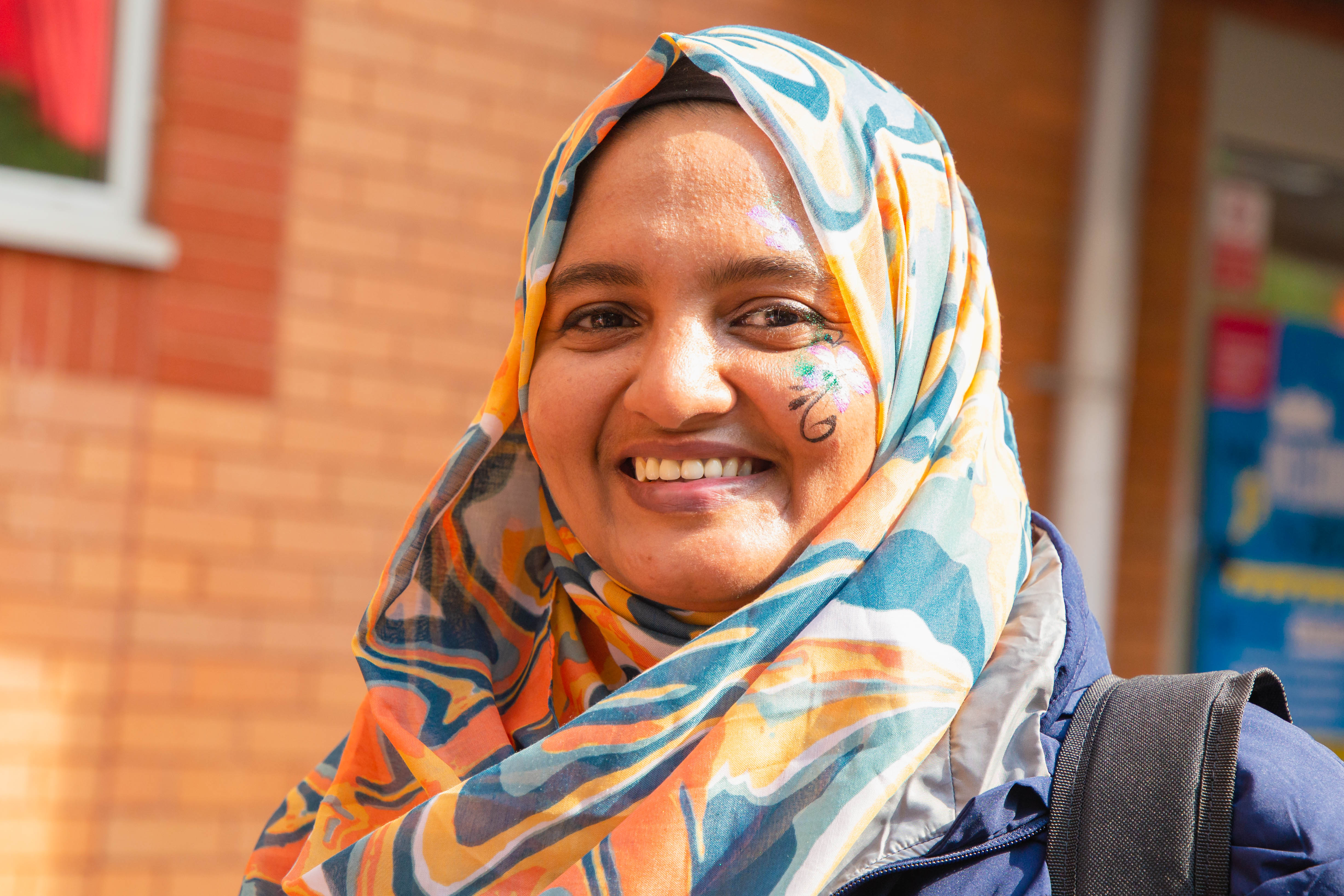 Student at welcome fest with face painted smiling to camera