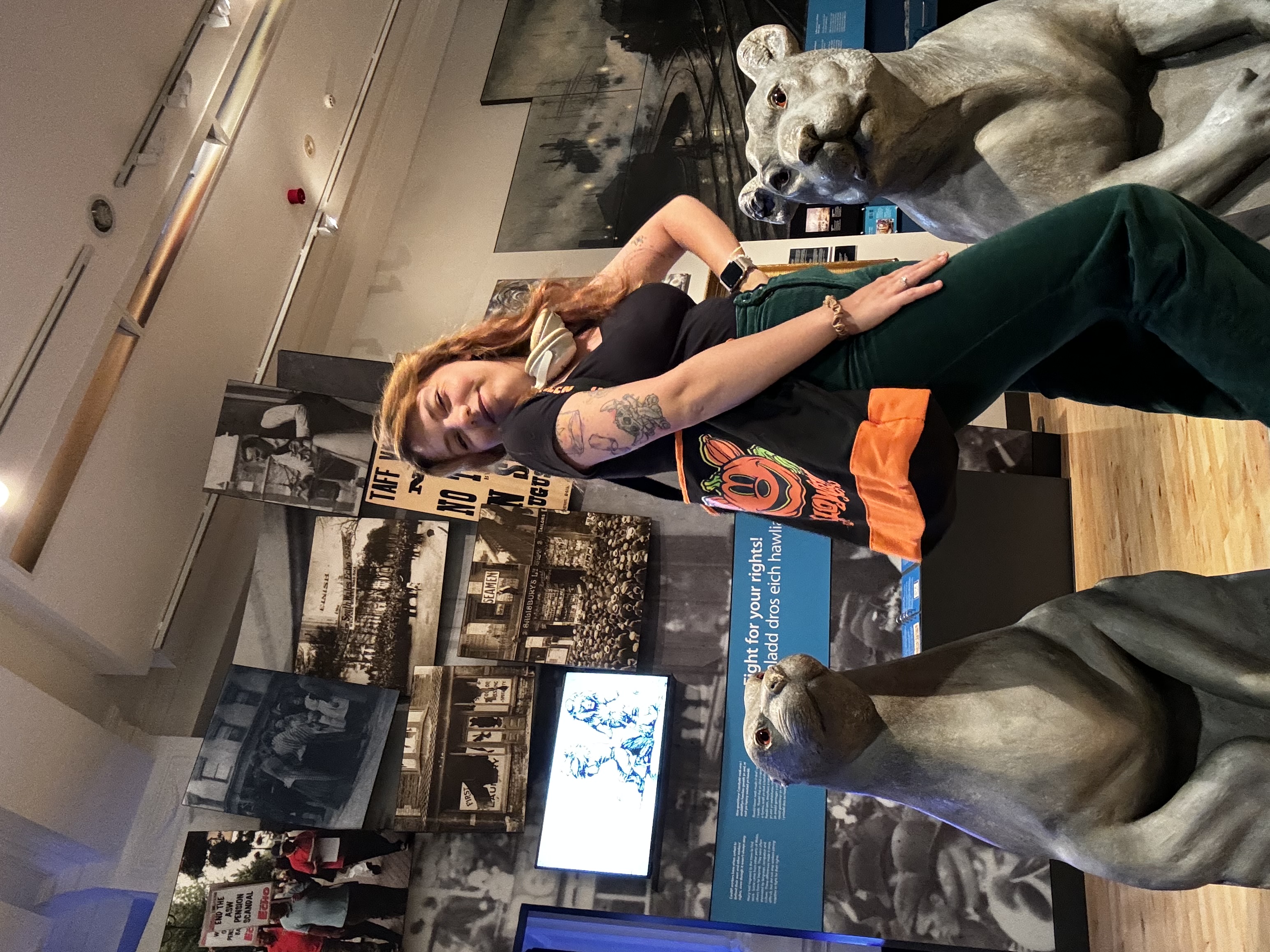 Student, Ashleigh, is posing between two animal statues in a shop.