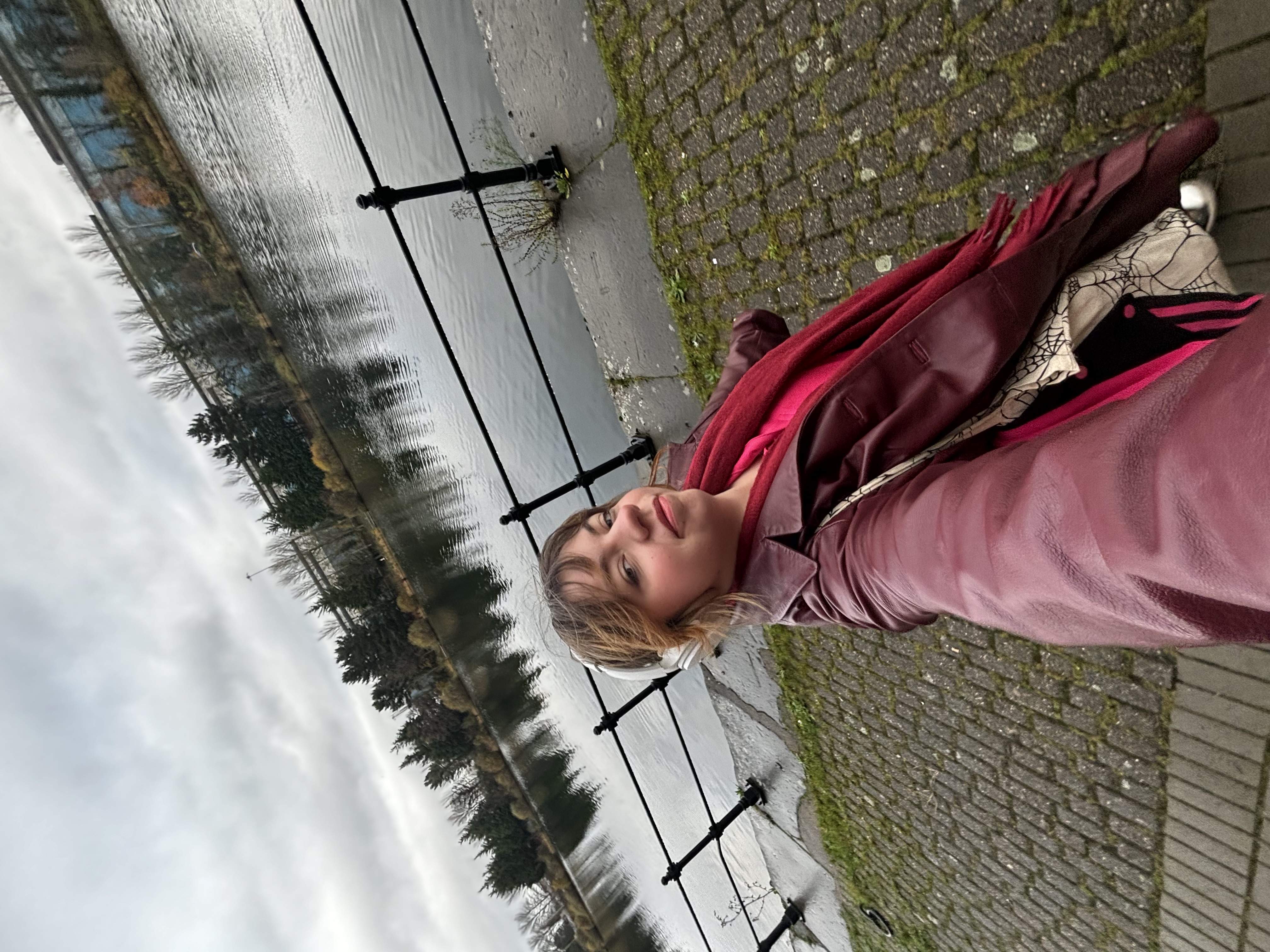Student, Ashleigh, is taking a selfie by the river.