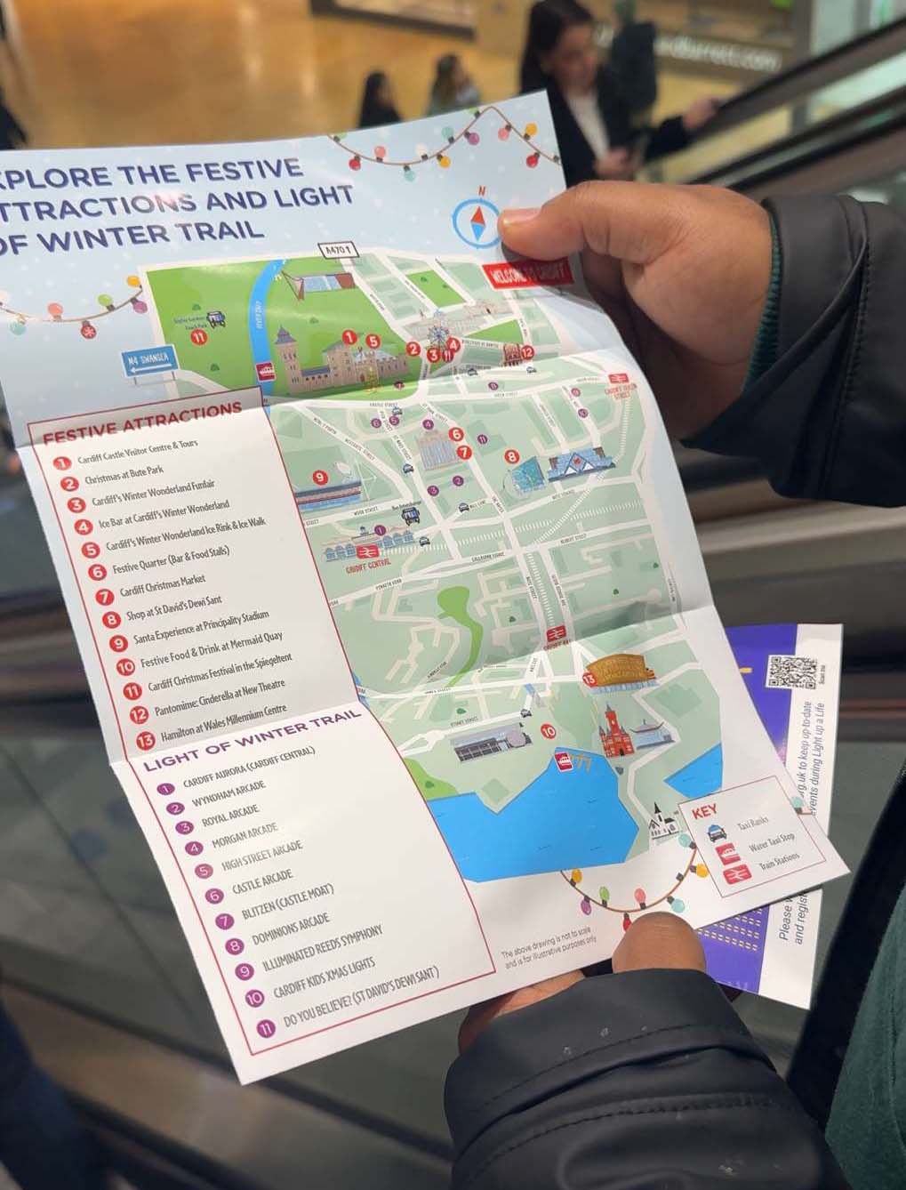 A close up of somebody holding a map that shows the Light of Winter trail locations across Cardiff.