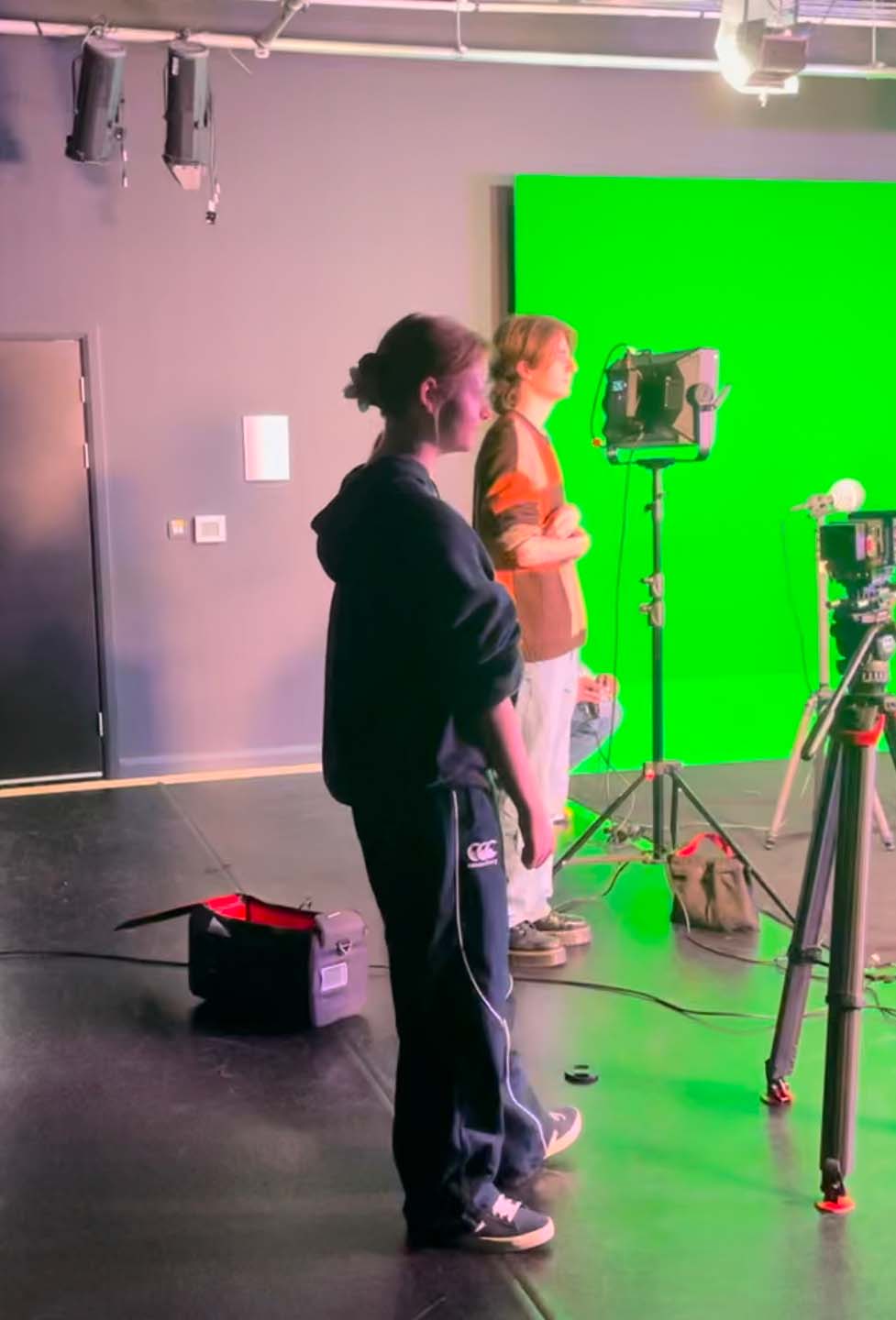 Performance and media students working on a production with a green screen background.