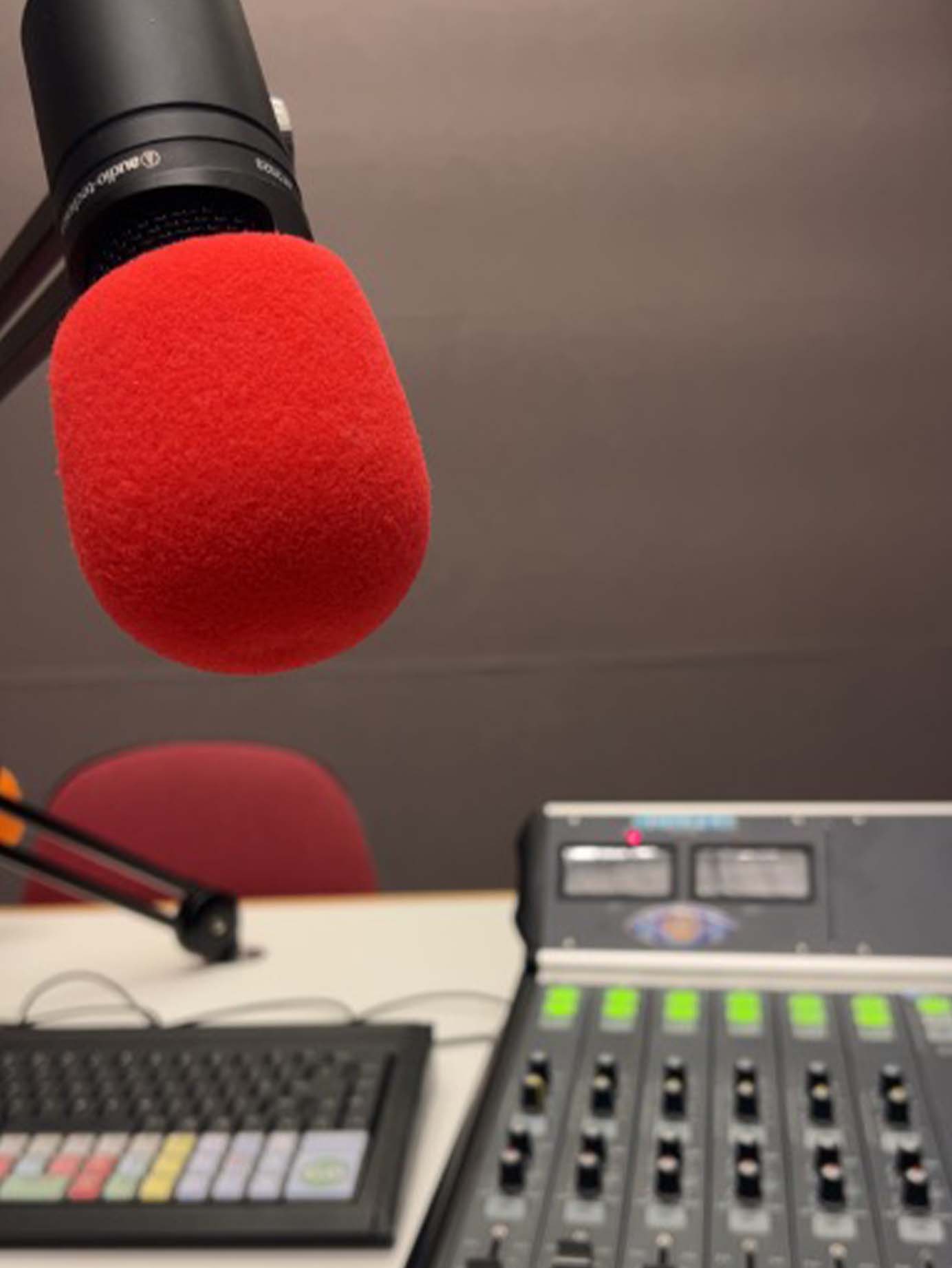 A red microphone and other recording equipment in a studio.