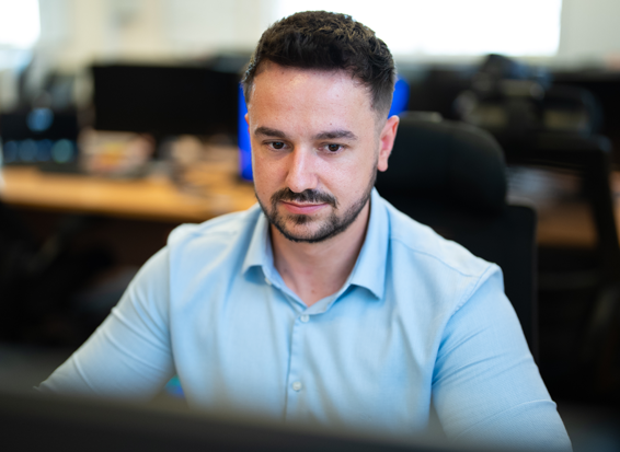 Digital Forensics Graduate William concentrates while sat at a computer in a USW computing laboratory