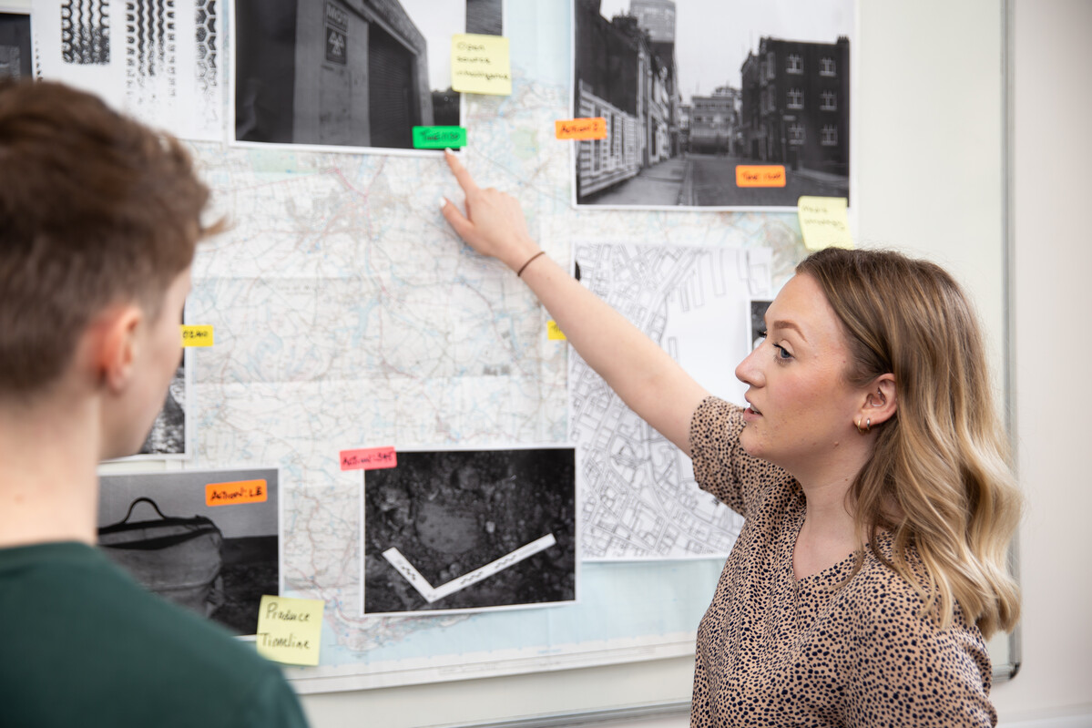 Students looking at evidence stuck to a wall.