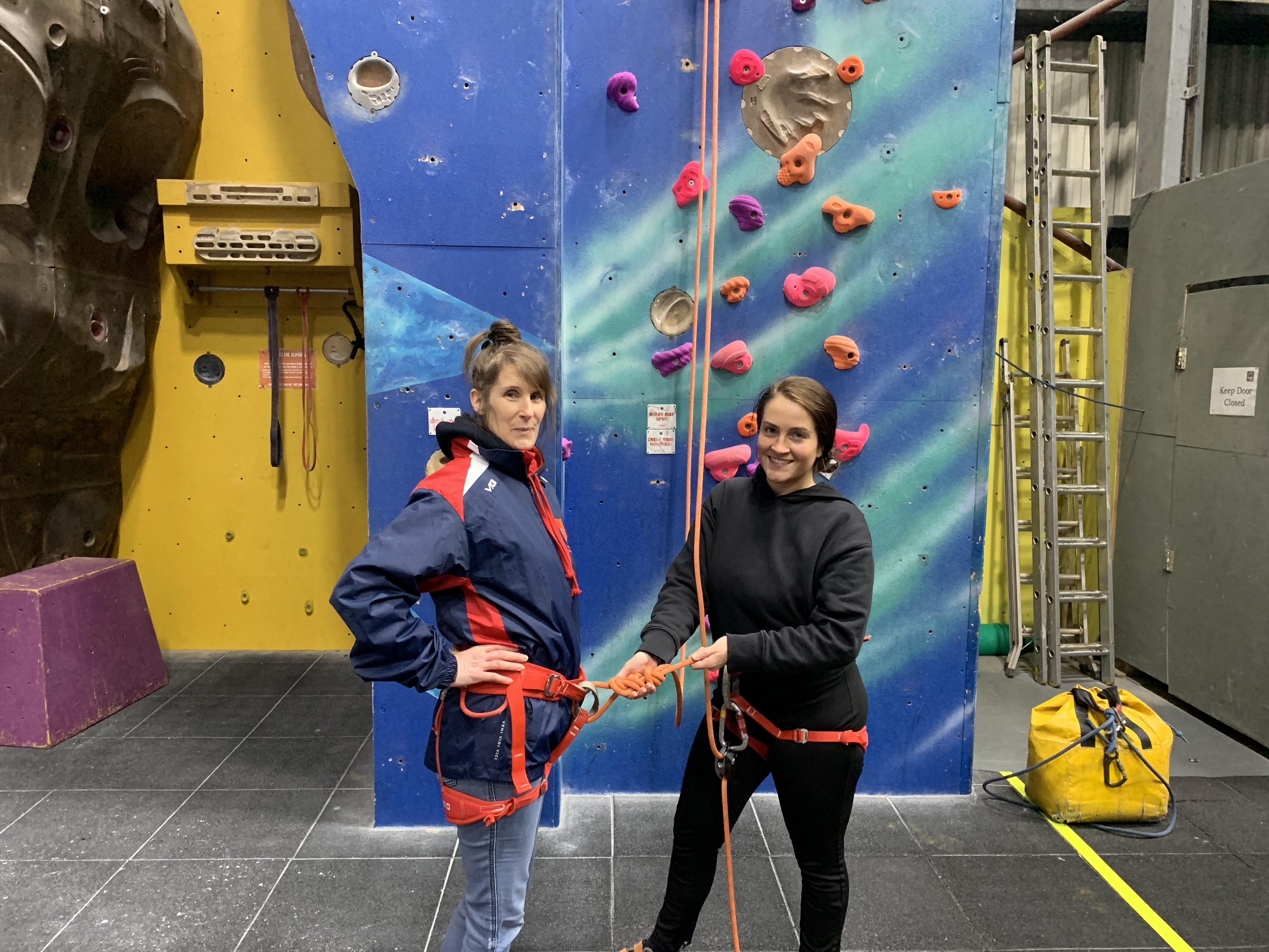 a lecturer and student in a practical session at a rock climbing centre