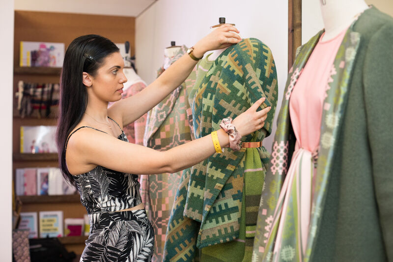 A student altering a garment on a mannequin at the USW Graduate Fashion Week 2019.