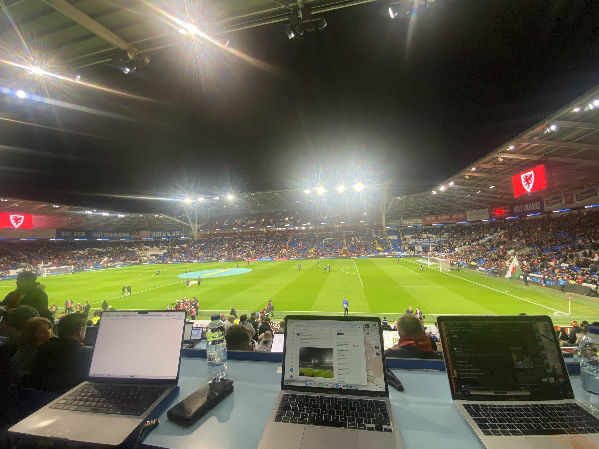 Three laptops pictured in the stands of a sports match that are being used for Sports Journalism reporting.