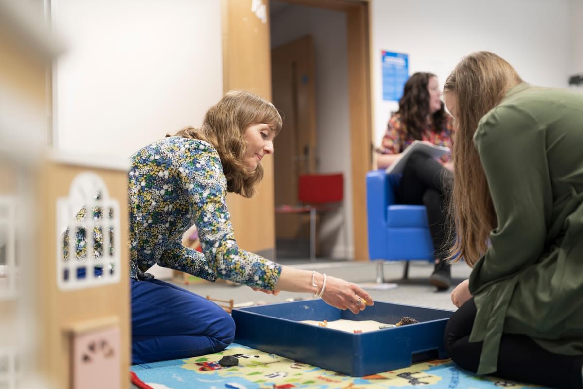 Students experimenting with toys and sand as a counselling technique
