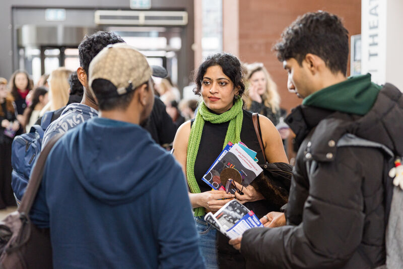 Students talking with brochures at Immersed Careers Fair