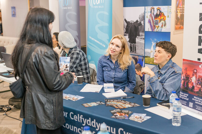 Student talking to people at a stand at Immersed Careers Fair