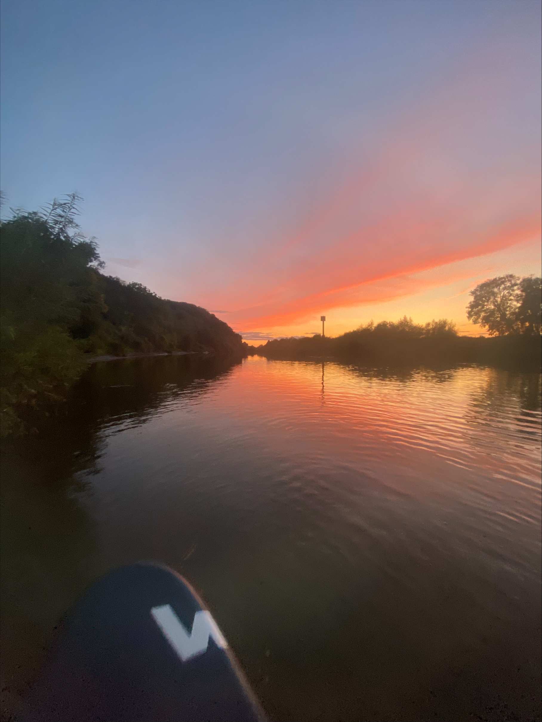 View from Lucy's paddleboard during a sunrise on a river