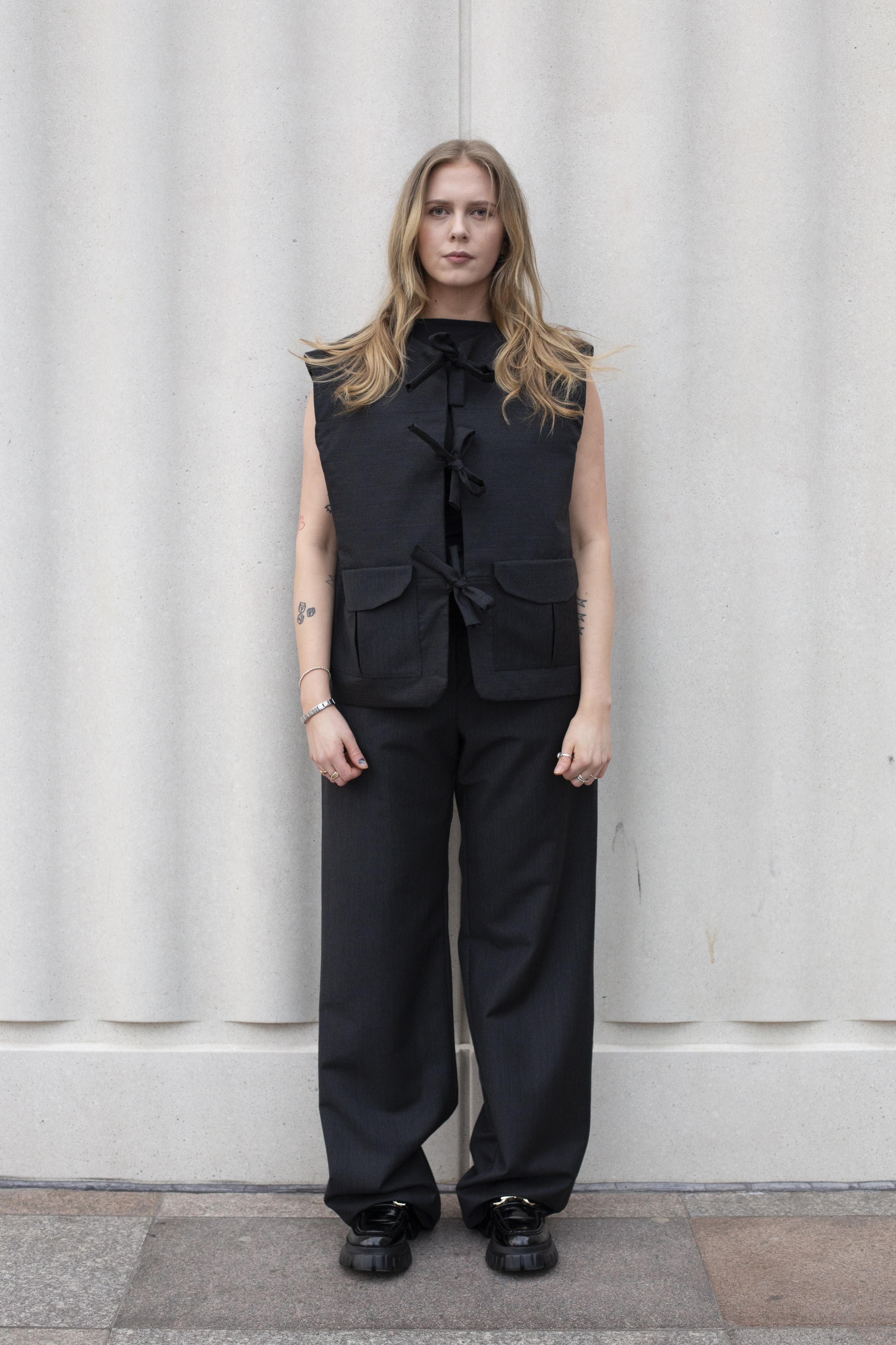 Model wearing a smart black vest and trousers