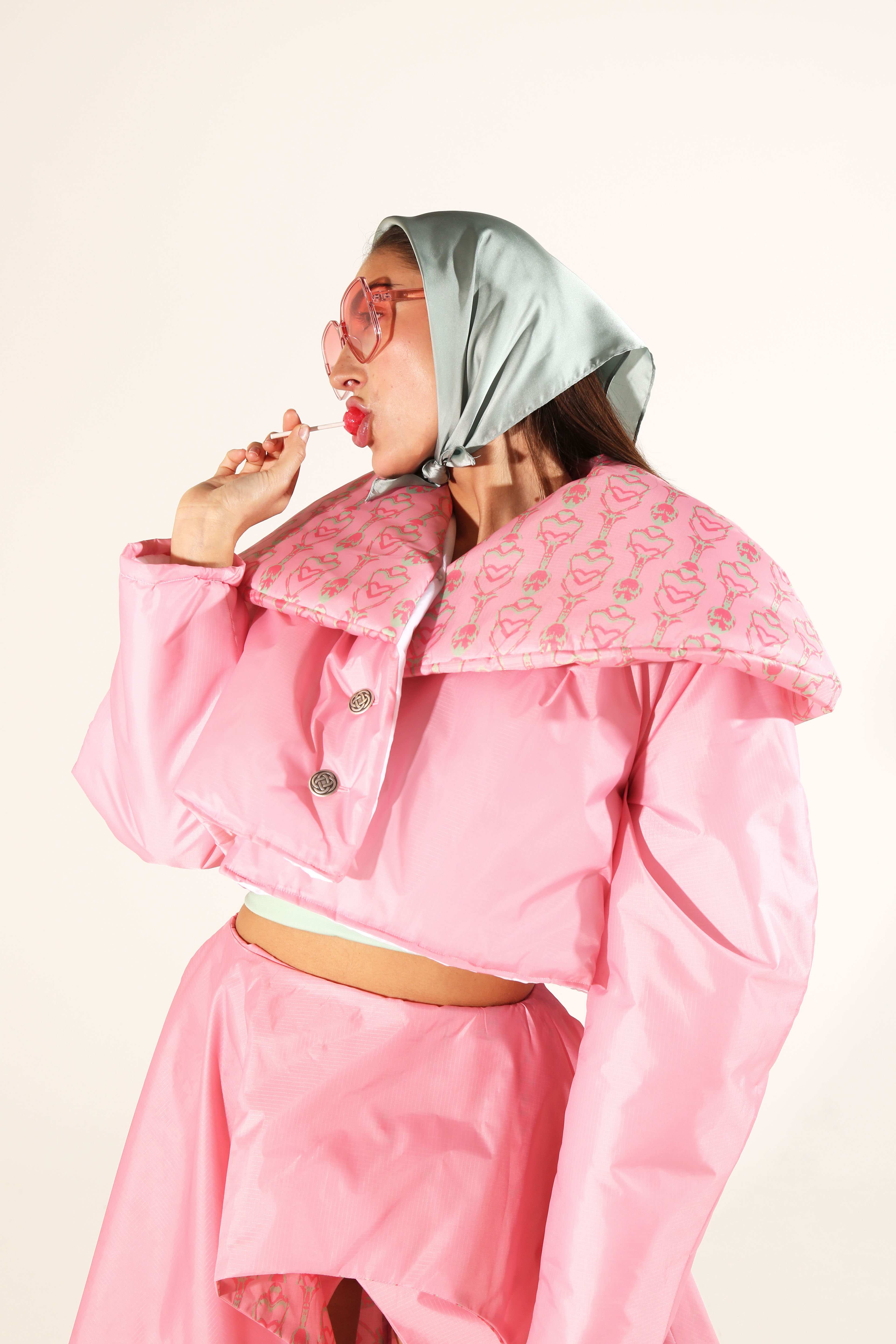 Photography of Fashion Student work - a model posing in a pink jacket and blue bonnet