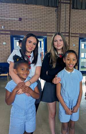Two younger pupils stand in front of two older pupils