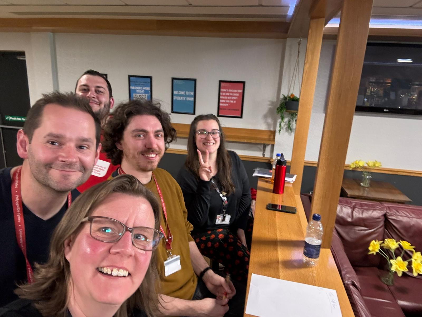a group of people sitting behind a desk
