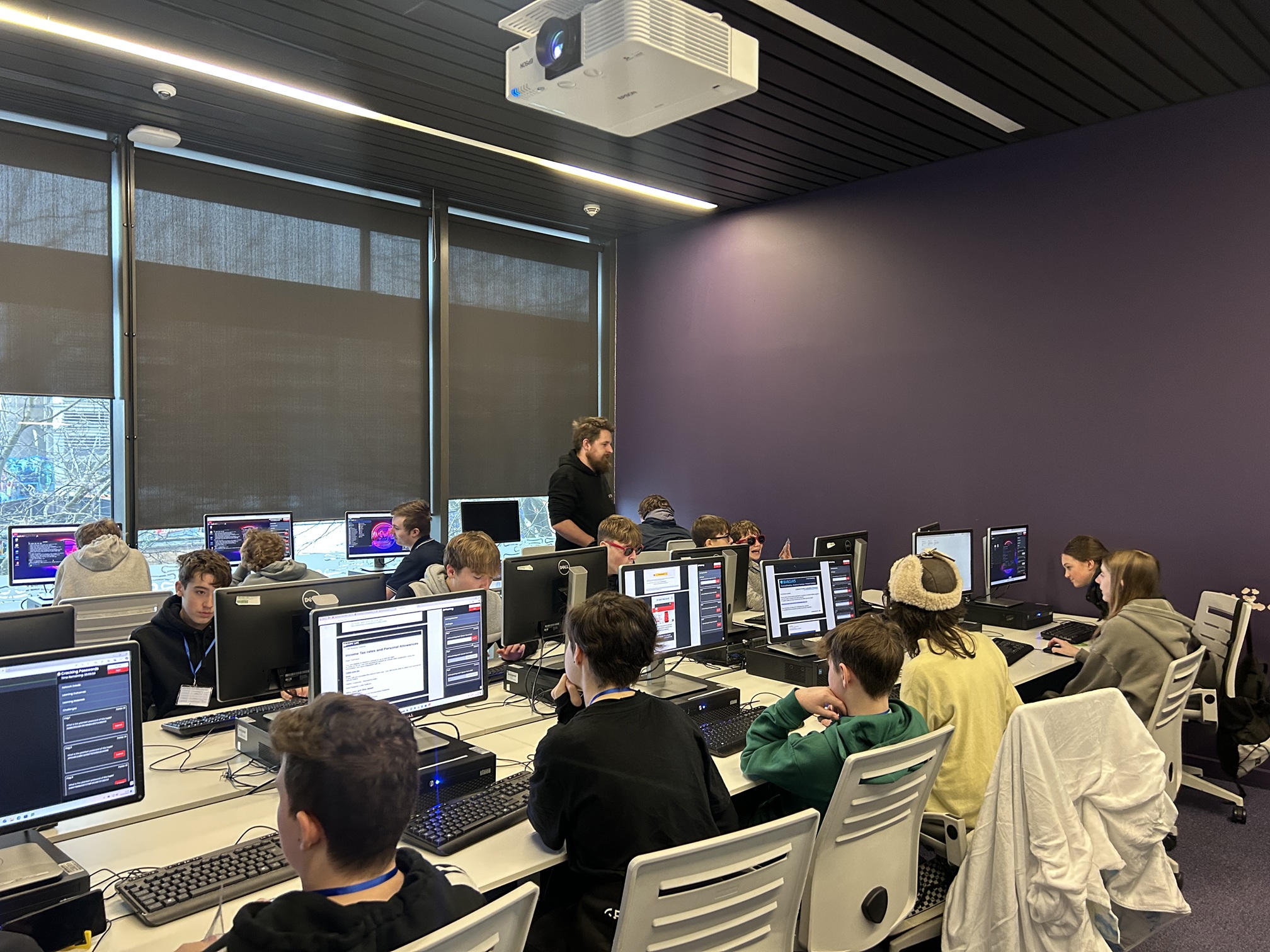 Students sitting in front of computer screens in a cyber laboratory at the University of South Wales